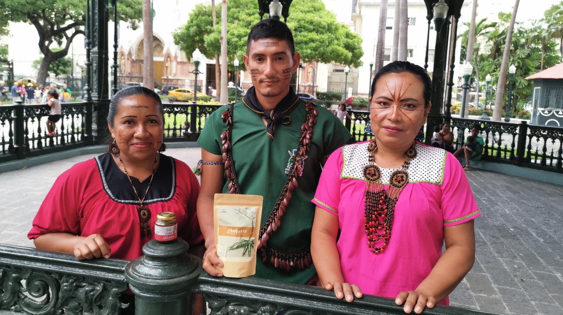 Yeny Quenawa (Izq.), Juan Herrera y Nilda Payaguaje con productos como la neapía y la fariña, en una visita a Guayaquil. 