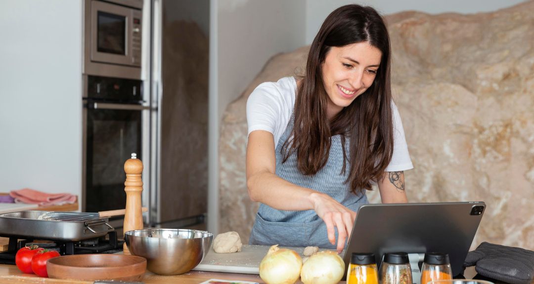 Mujer siguiendo una clase de cocina virtual