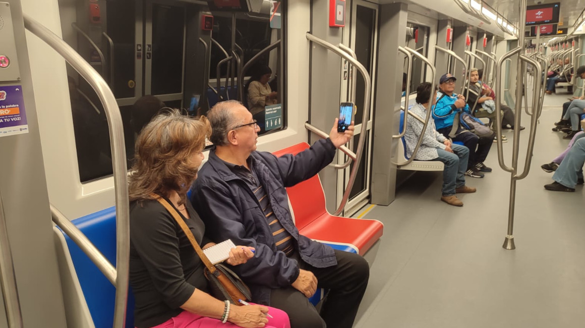 Dos usuarios del Metro de Quito se toman una foto, el 1 de diciembre de 2023.