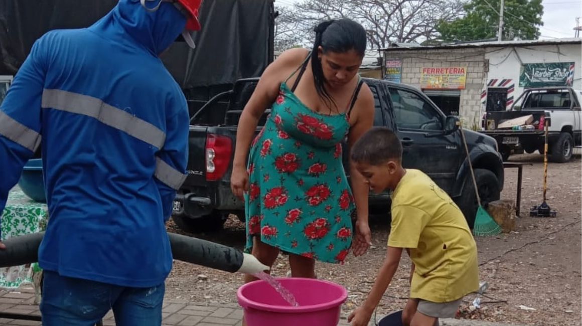 Una familia recibe agua de un tanquero en Guayaquil.