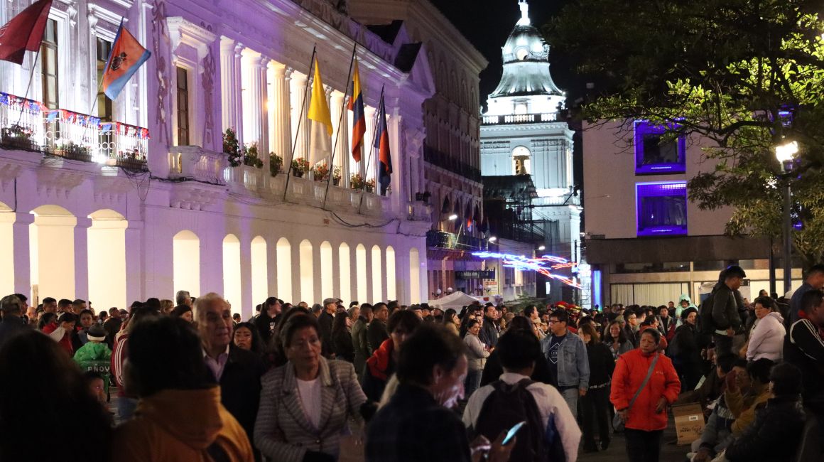 Cientos de personas caminan en el centro de Quito, durante las fiestas de fundación, en diciembre de 2023.