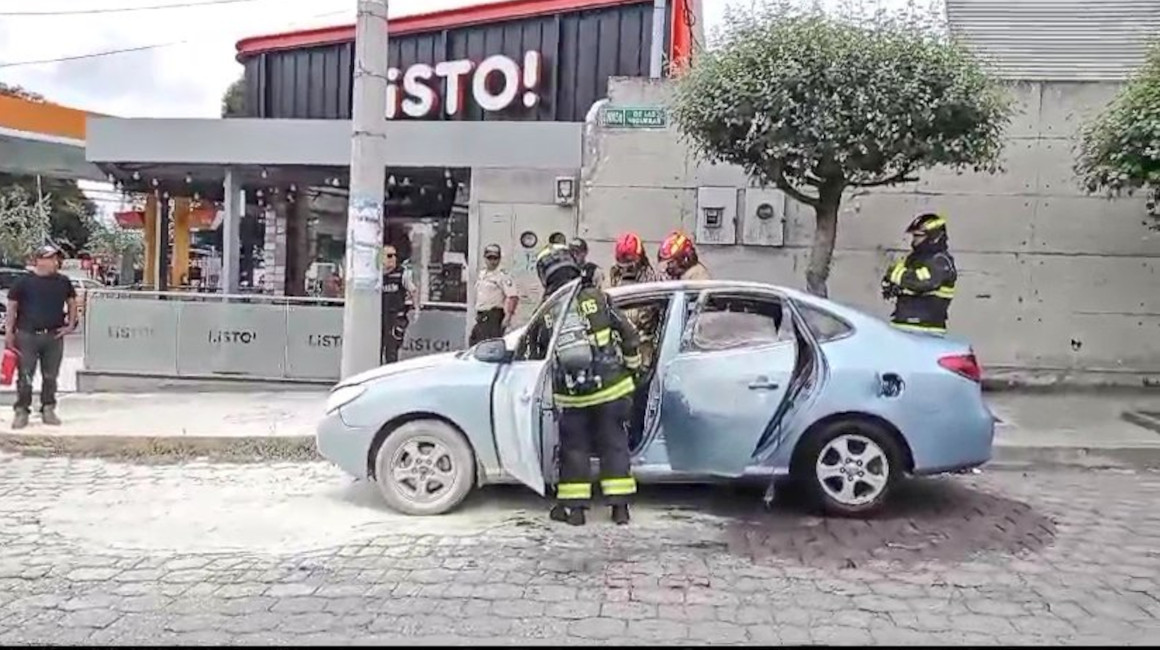 Bomberos controlan un incendio provocado en un vehículo en el sector de Monteserrín, en el norte de Quito, el 10 de enero de 2024.
