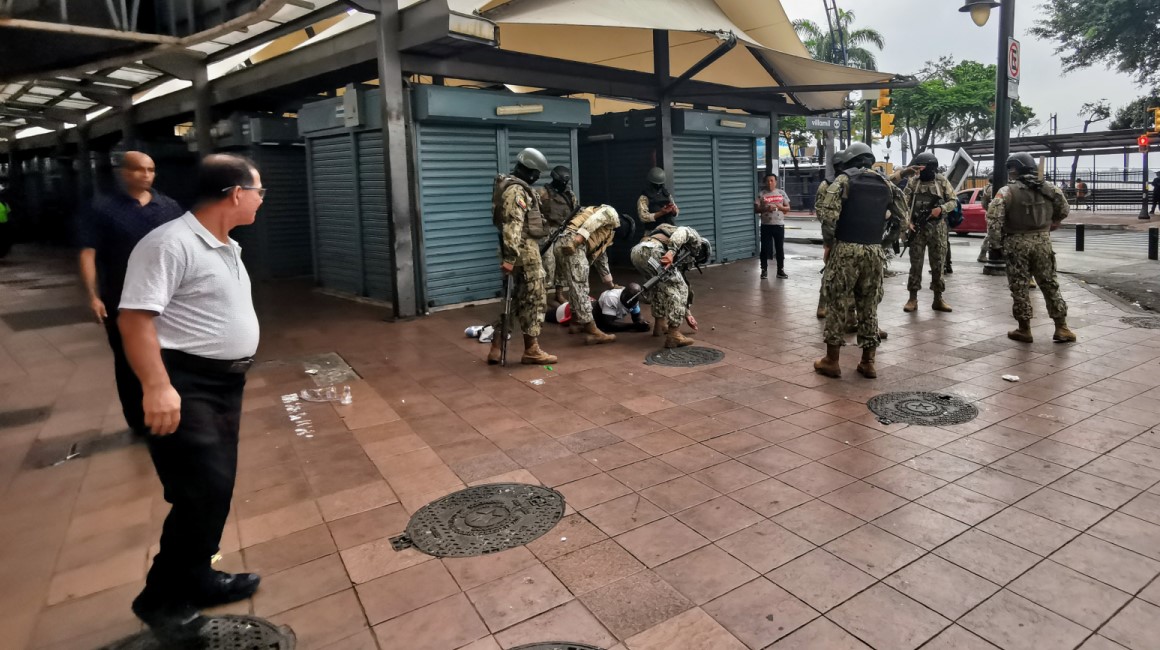 Militares someten a un sospechoso en el sector comercial de la Bahía, centro de Guayaquil, donde negocios permanecieron cerrados este miércoles 10 de enero del 2024.