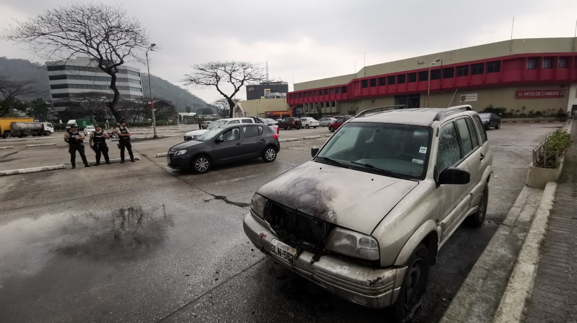 Un vehículo incinerado en el parqueo del centro comercial Albán Borja, al norte de Guayaquil, que atendió a medias este miércoles 10 de enero, tras un tiroteo con dos fallecidos la tarde previa. 