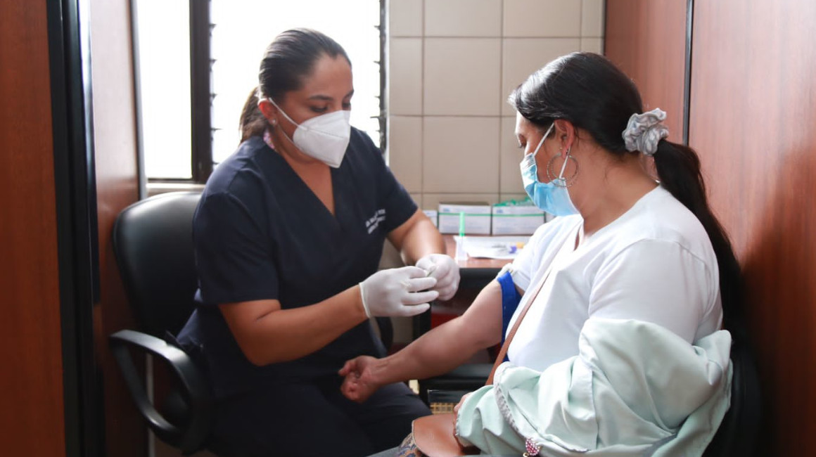 Una trabajadora del IESS ofrece atención médica a un paciente.
