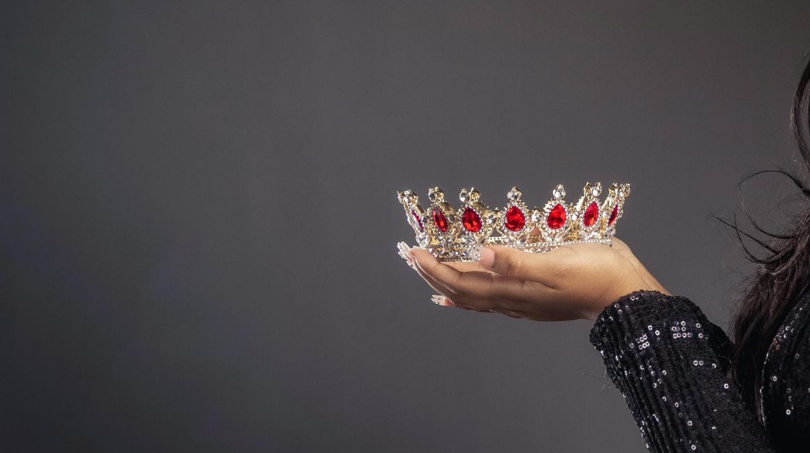 Imagen referencial de una mujer sosteniendo una corona.