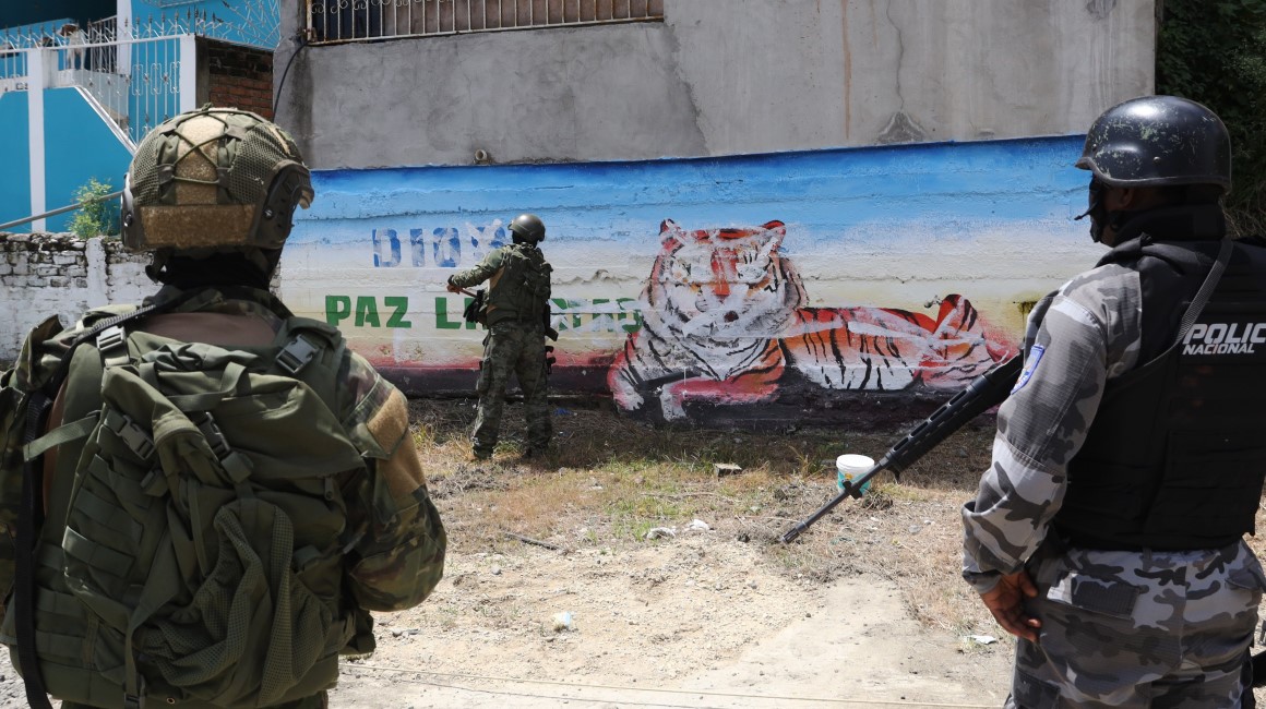 Militares y policías borran el tigre de un mural de la banda Los Tiguerones, en Esmeraldas.