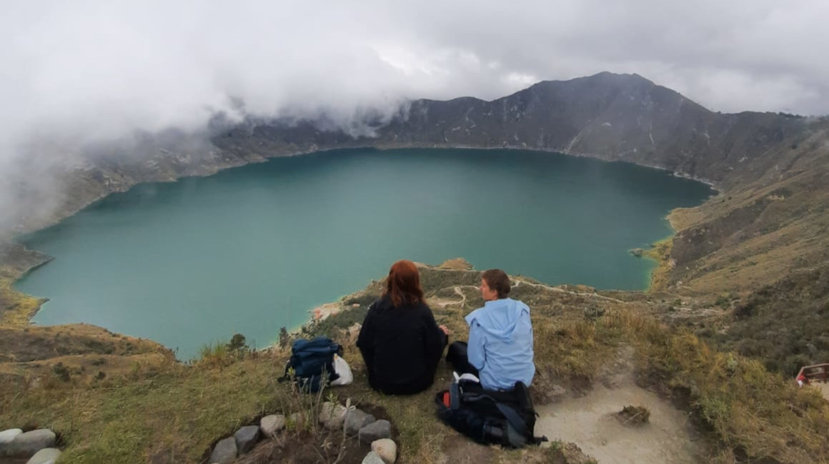 Dos turistas extranjeros frente a la Laguna del Quilotoa, provincia de Cotopaxi. Foto de 2023.