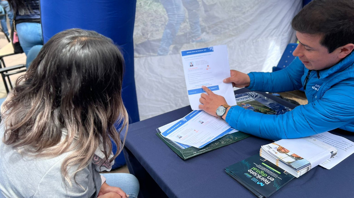 Una joven recibe información sobre la bolsa de empleo del Ministerio del Trabajo, en la feria Infancia con Futuro, realizada en Cotopaxi, en marzo de 2023.