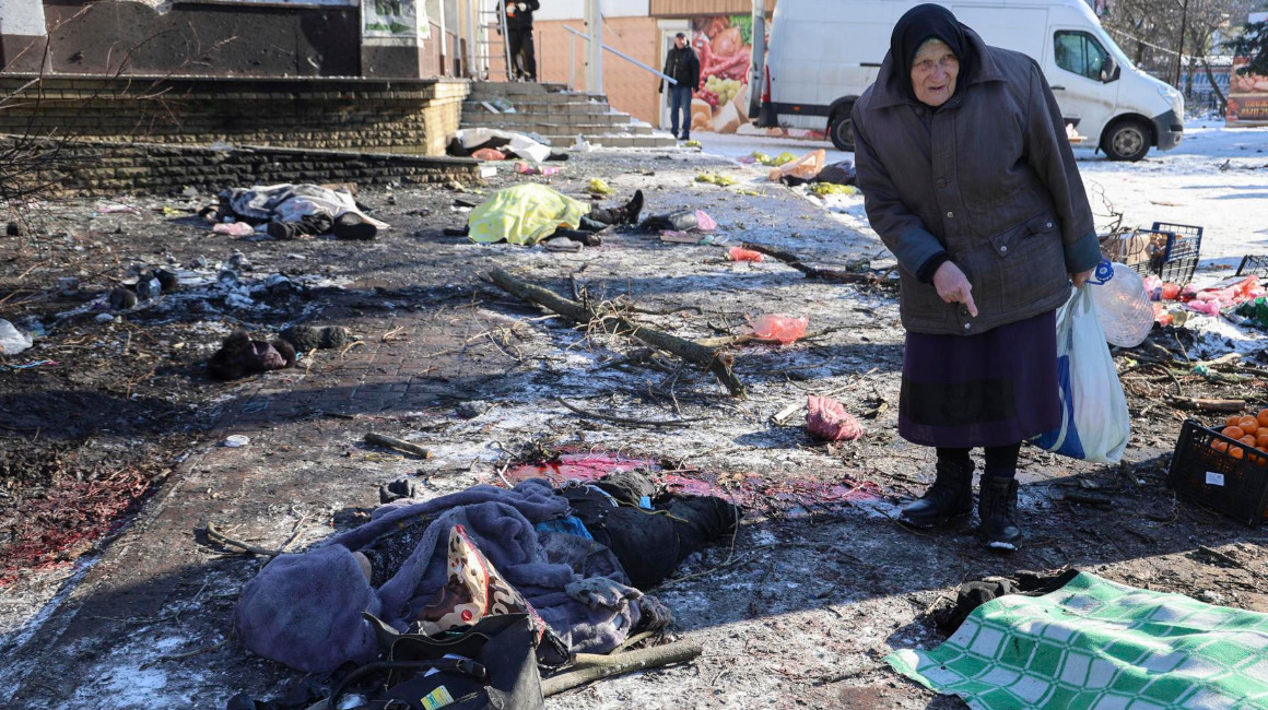 Una mujer se encuentra entre los cuerpos cubiertos de las víctimas que murieron en el bombardeo del mercado de alimentos en Donetsk, al este de Ucrania, el 21 de enero de 2024.