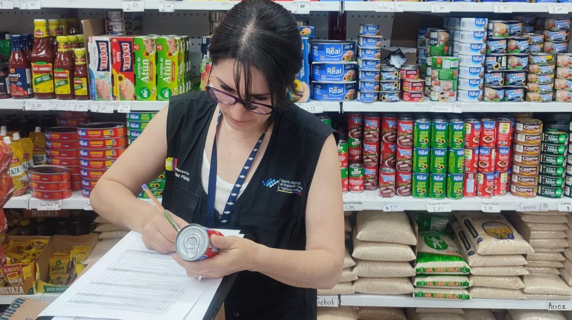 Personal de la Arcsa verifica las latas de sardinas en una tienda de Azuay, el 25 de enero de 2024.