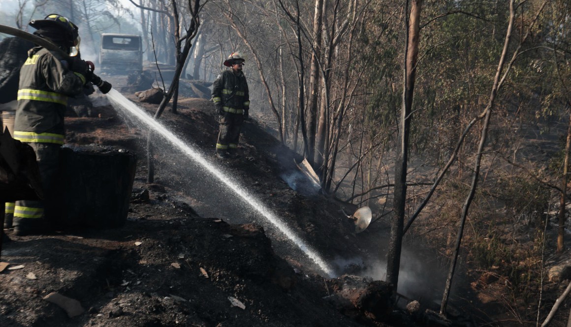 Bomberos y voluntarios tratan de extinguir los focos de un incendio hoy, en la zona de Patagual, Chile.