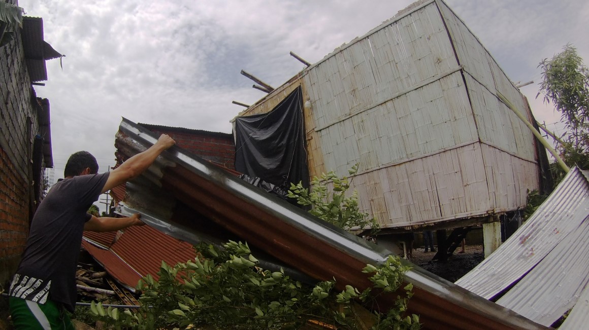 Las láminas de zinc volaron por hasta 20 metros en el barrio Nueva Unida Sur, de Milagro, donde 17 familias resultaron afectadas. Un hombre intenta rescatar una lámina en la casa de la familia Carpio.