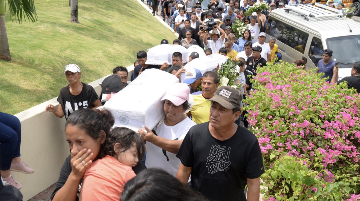 Familiares y amigos cargan los ataúdes de cuatro niños asesinados por hombres armados durante su funeral en Pascuales, al norte de Guayaquil, el 14 de diciembre de 2023.