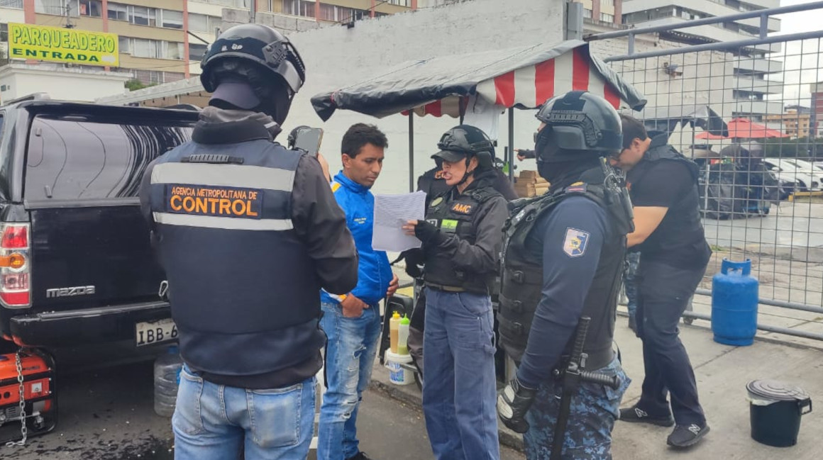 Un agente municipal le notifica el retiro de su mercadería a un vendedor informal, el 14 de marzo de 2024 en Quito.