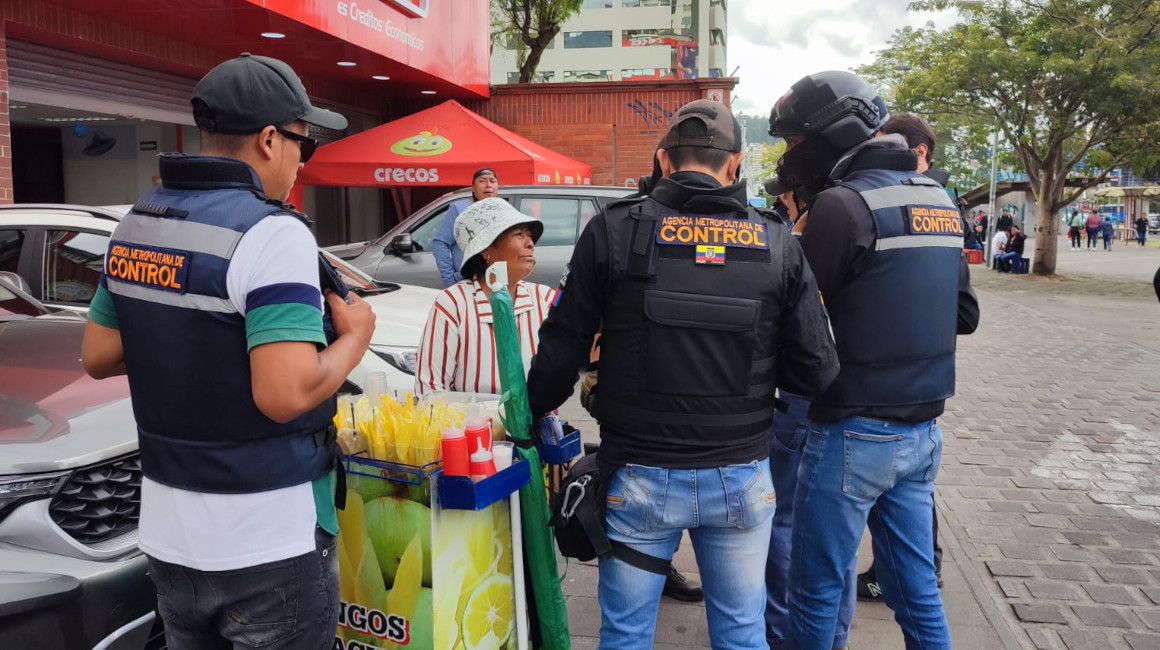 Una comerciante informal en Quito es abordada por agentes municipales, el 14 de marzo de 2024.