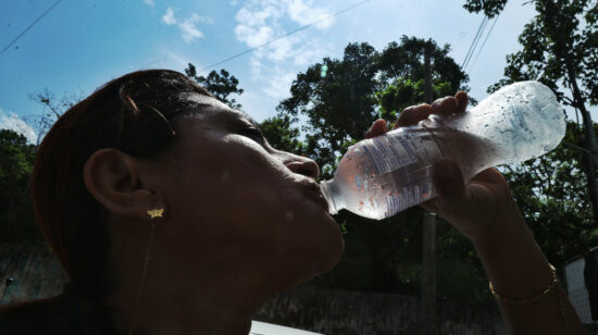 Una mujer toma de una botella de agua en medio de la ola de calor en Guayaquil, el 19 de marzo de 2024.