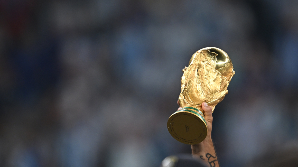 El trofeo de la Copa Mundial de la FIFA se sostiene en alto mientras los jugadores de Argentina celebran su victoria sobre Francia el 18 de diciembre de 2022.