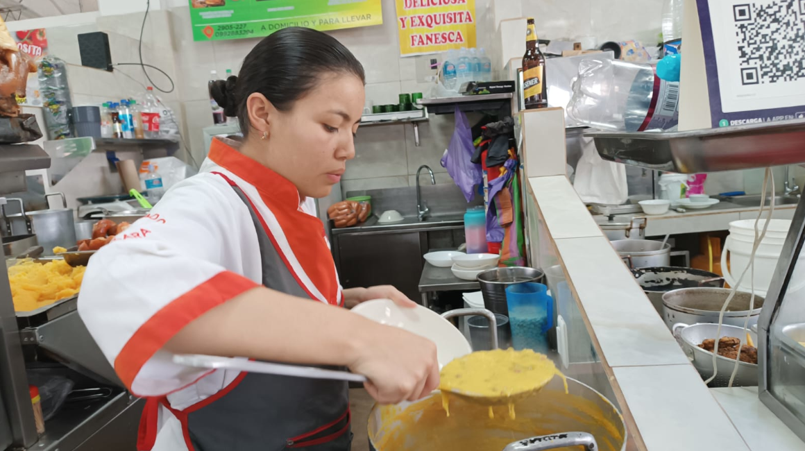 Una trabajadora de un local de comida en el mercado Santa Clara, en Quito, sirve un plato de Fanesca, 20 de marzo de 2024.