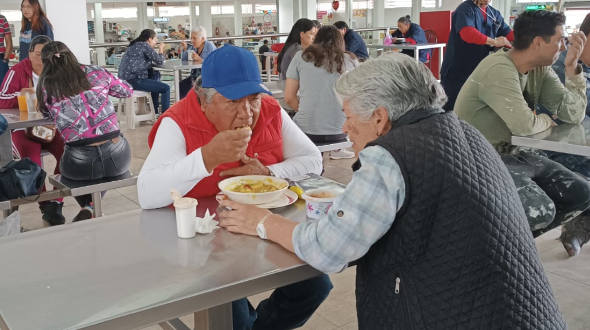 Dos personas comen fanesca en el mercado de Santa Clara, en Quito, 20 de marzo de 2024. 
