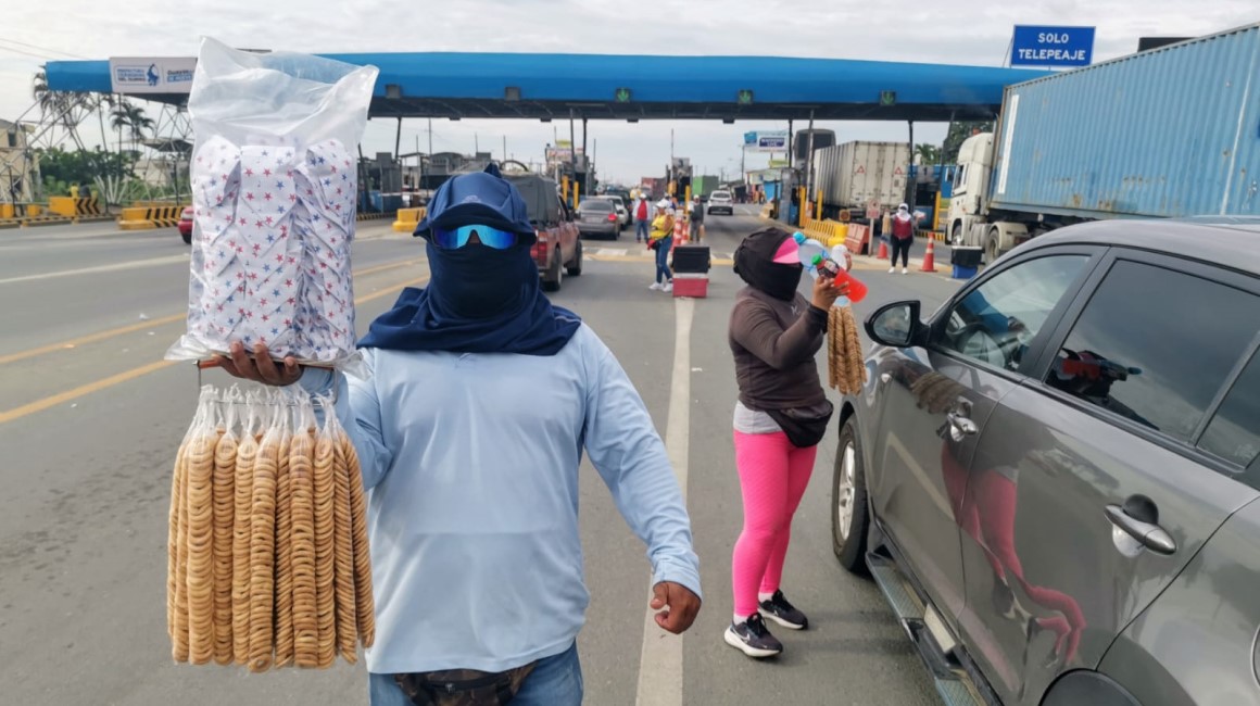 Vendedores se cubren completamente ante rayos ultravioleta en el Peaje Chivería, ingreso a Nobol (Guayas), uno de los cantones que ha superado la barrera de los 36°C.