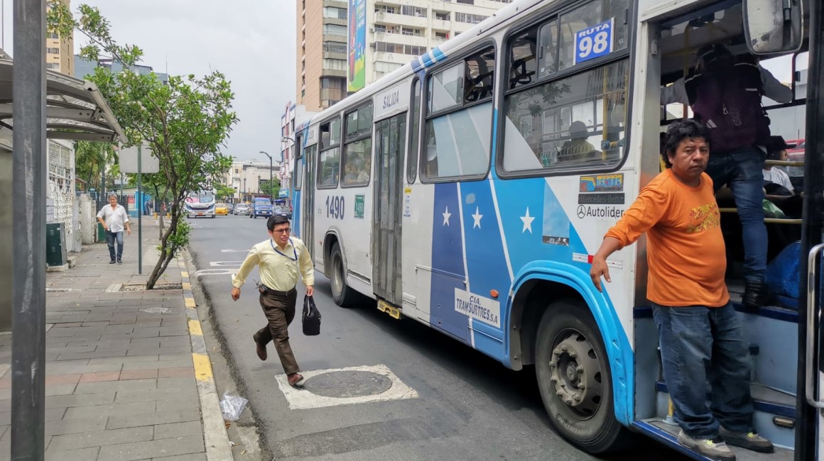 Un hombre corre para subirse "al vuelo" a un bus en el centro de Guayaquil. La nueva tarifa del pasaje del transporte público en Guayaquil se definirá hasta el 4 de abril de 2024.