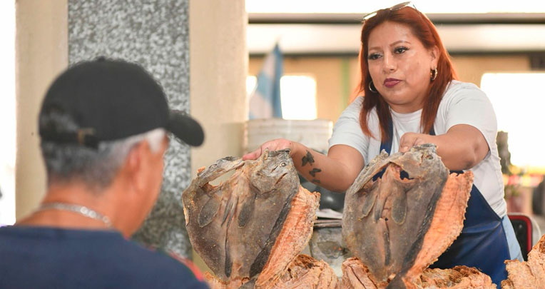 Cliente compra un pescado en un mercado de Guayaquil.