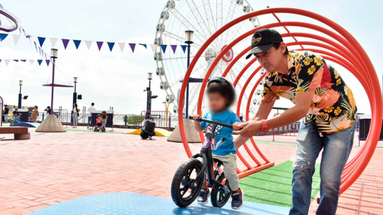 Un niño junto a su padre disfrutan de las actividades en el Malecón 2000, en Guayaquil.