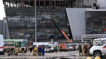 El personal de los servicios de emergencia trabaja junto a la sala de conciertos Crocus City Hall incendiada en Moscú.