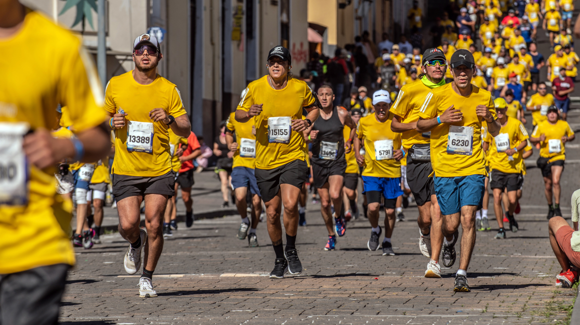 Atletas pasan por el centro histórico durante la edición 2023 de la Quito 15K.