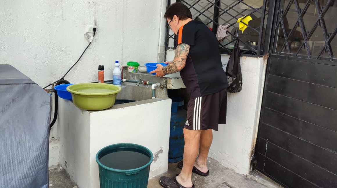 Un morador de Conocoto verifica el agua que recogió de su cisterna, el 8 de abril de 2024.