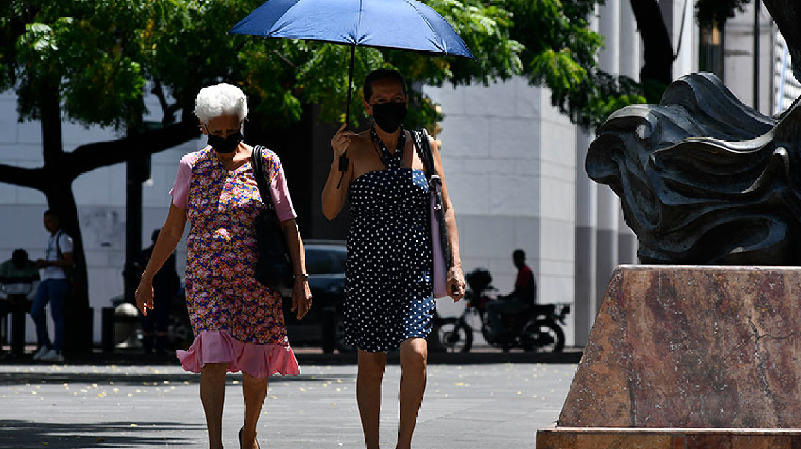 Dos mujeres se protegen con una sombrilla del sol en Guayaquil en marzo de 2024.