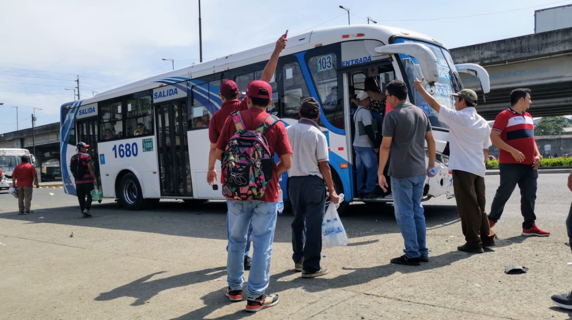 Pasajeros esperan por una unidad de bus urbano en la vía Perimetral, al noroeste de Guayaquil.