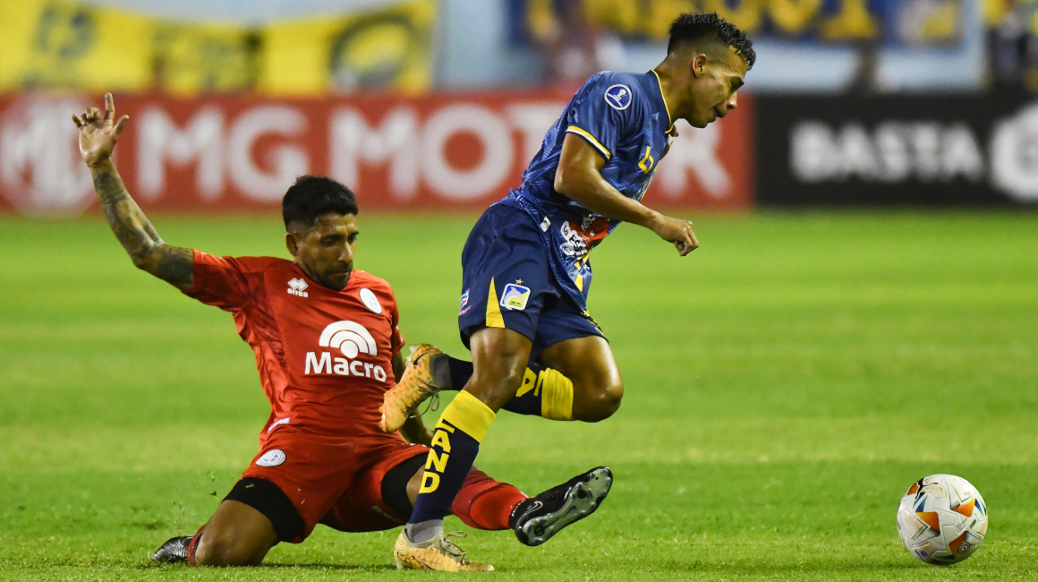 Maikel Reyes AlcÍvar (d) de Delfín disputa el balón con Ariel GarcÍa de Belgrano este 11 de abril de 2024, en un partido de la fase de grupos de la Copa Sudamericana.