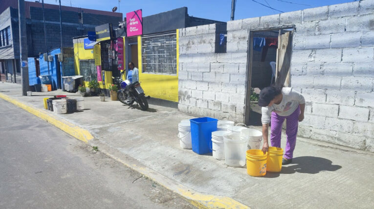 Habitantes del barrio Pilsulí Alto, en el norte de Quito, colocan baldes frente a sus viviendas, el 24 de abril de 2024.
