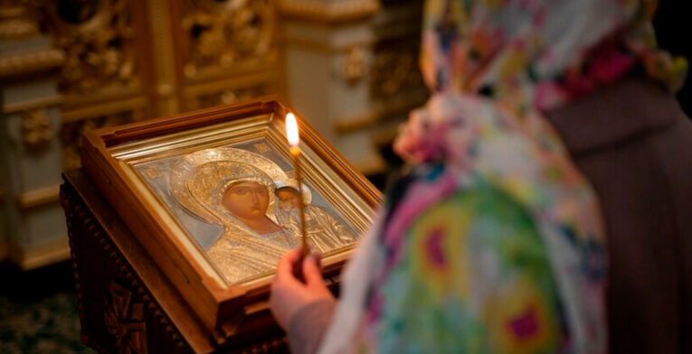 Imagen referencial. Una mujer reza a un cuadro de la Virgen María en un iglesia.