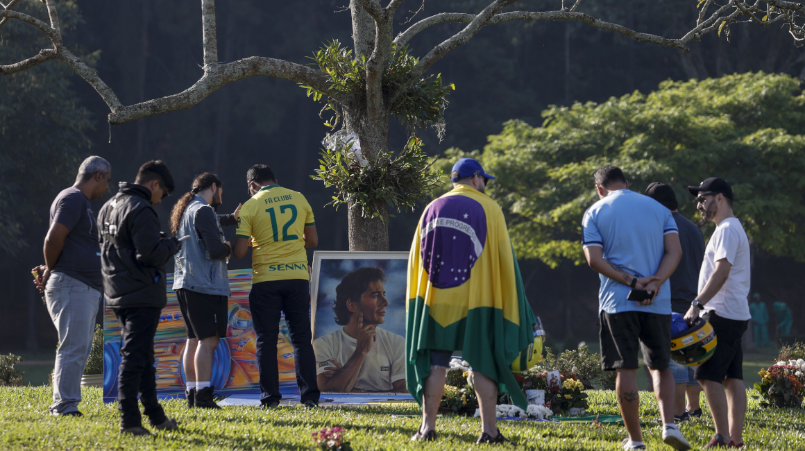 Seguidores del automovilista brasileño Ayrton Senna muestran respeto frente a la tumba del piloto este miércoles 1 de mayo de 2024, cuando se conmemoran tres décadas de su fallecimiento.