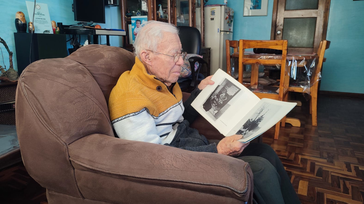 Luis Mejía observa un libro que recoge sus fotografías en su casa, el 30 de abril de 2024.