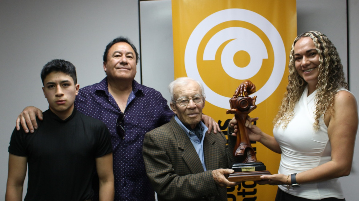 Luis Mejía (centro) con el premio entregado por la Asociación de Fotógrafos del Ecuador, el 20 de abril de 2024.