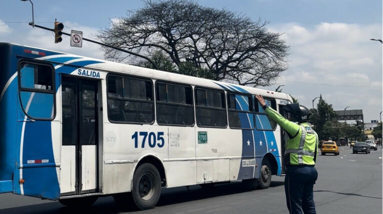 Un agente de la ATM cerca de uno de los buses de transporte urbano en Guayaquil, el 20 de abril de 2024.