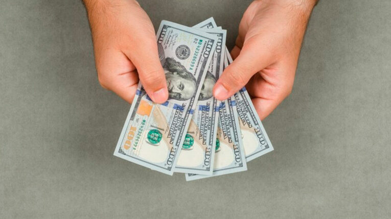 Imagen referencial de una persona con dinero en sus manos.