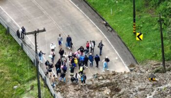 Viajeros que se quedaron varados en el sector Marianza, de Sayausí, en la vía Cuenca-Molleturo-El Empalme, intentan avanzar a pie.