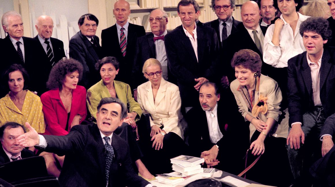 El periodista y presentador de televisión francés Bernard Pivot (al frente), rodeado de escritores como Gabriel Matzneff, Bernard-Henri Levy y artistas invitados durante el último programa de televisión 'Apostrophes' en el canal Antenne 2, el 22 de junio de 1990, en París.