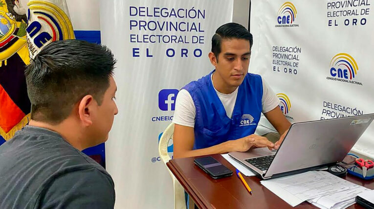 Ciudadano realiza un trámite con un funcionario del Consejo Nacional Electoral de Ecuador.