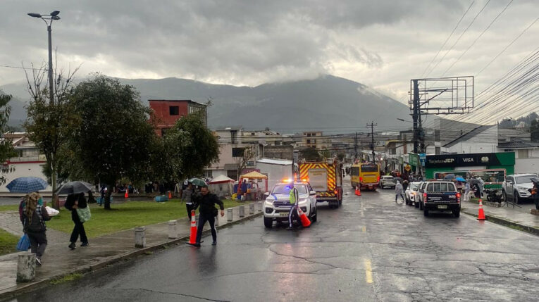 Personas caminan bajo la lluvia en un barrio de Quito el 11 de mayo de 2024.