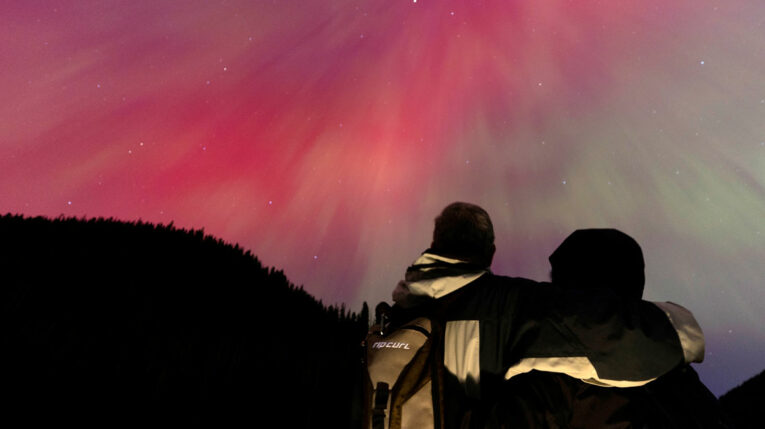Una pareja observa una aurora boreal, el 11 de mayo de 2024 en Manning Park, Columbia Británica, Canadá.