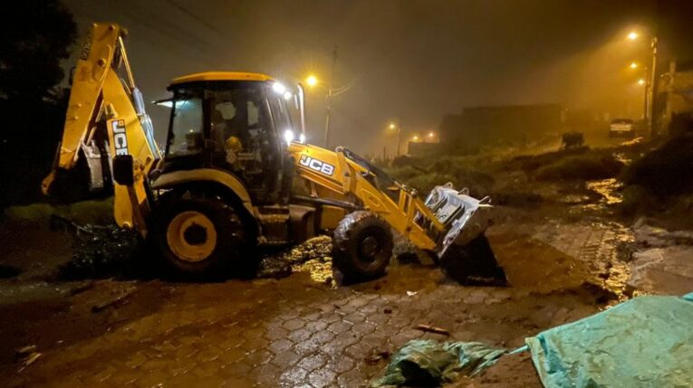 Maquinaria trabaja en la limpieza de escombros tras un deslizamiento en el sector Edén del Sur, en Quito, el 14 de mayo de 2024.