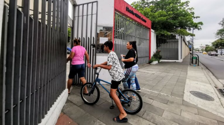 Padres de familia ingresas con un niño en bicicleta al distrito centro del Ministerio de Educación en Guayaquil.