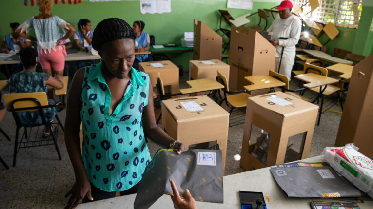 Una mujer recibe el material para votar este domingo en Santo Domingo. República Dominicana, durante la jornada de elecciones en ese país.