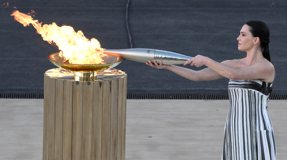 La actriz griega Mary Mina, en el papel de Suma Sacerdotisa, enciende la antorcha olímpica durante la ceremonia de entrega de la Llama Olímpica para los Juegos Olímpicos y Paralímpicos de Verano de París 2024 en el estadio Panathinean de Atenas, el 26 de abril de 2024.